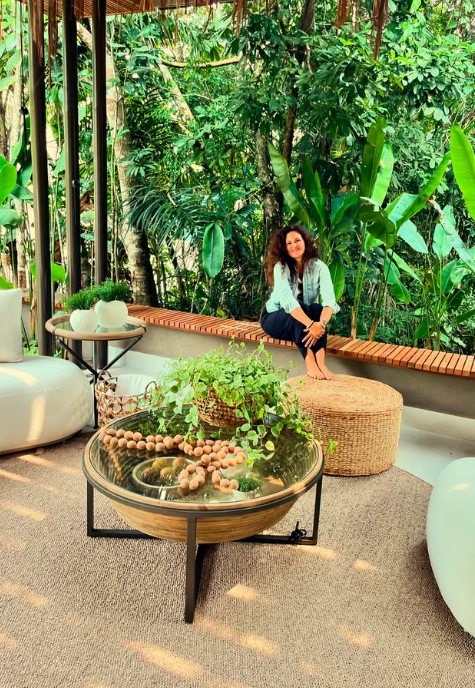 Ursula Bergamini em uma varanda cercada por plantas